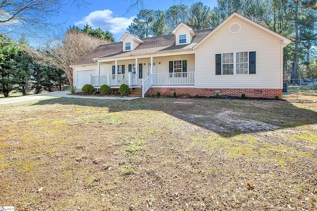 new england style home with a porch, an attached garage, crawl space, driveway, and a front lawn