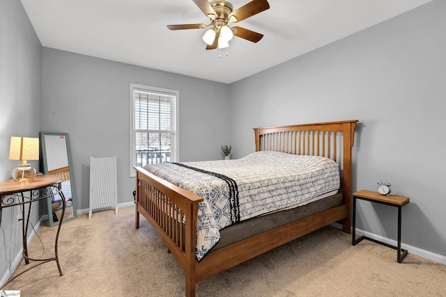 bedroom featuring radiator heating unit, baseboards, and light colored carpet