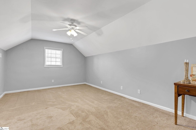 bonus room with a ceiling fan, lofted ceiling, light carpet, and baseboards