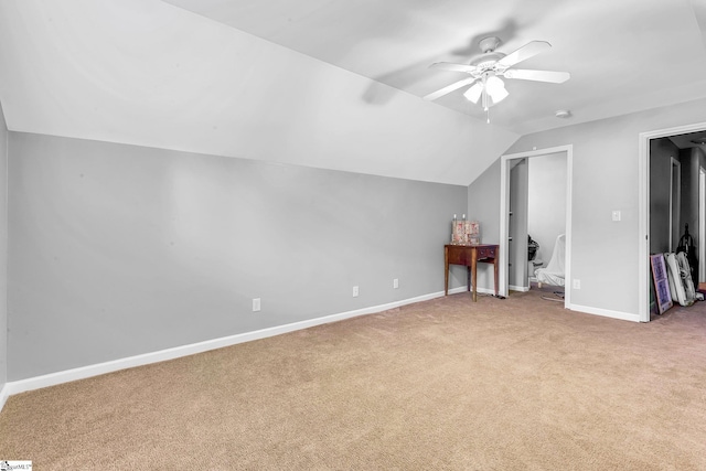 additional living space featuring a ceiling fan, light colored carpet, vaulted ceiling, and baseboards