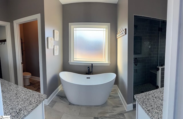 bathroom featuring a freestanding bath, marble finish floor, vanity, and baseboards