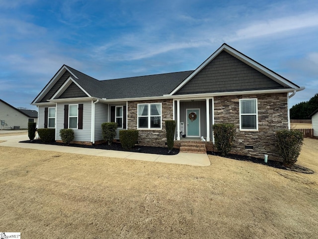 view of front facade with stone siding, a front yard, and crawl space