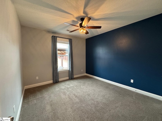 carpeted spare room featuring a textured ceiling, baseboards, and a ceiling fan