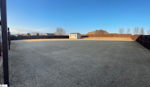 view of yard featuring an outbuilding, a storage unit, and a fenced backyard