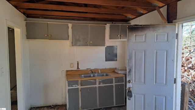 kitchen featuring light countertops, electric panel, a sink, and gray cabinetry