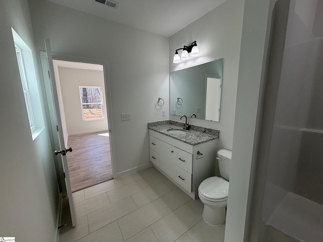 full bath with toilet, visible vents, vanity, baseboards, and tile patterned floors