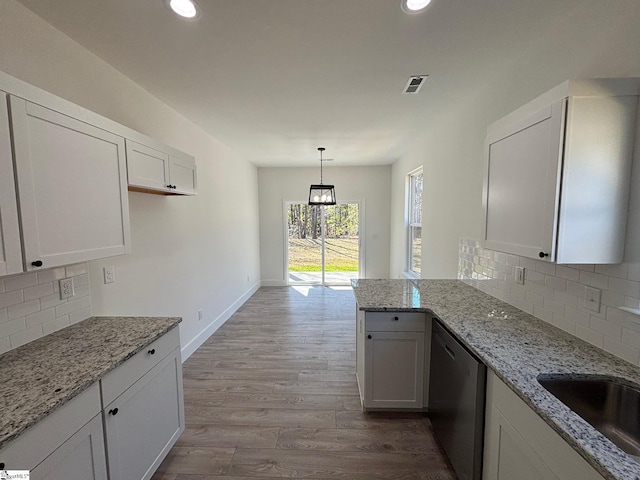 kitchen featuring a sink, visible vents, white cabinets, stainless steel dishwasher, and light wood-type flooring