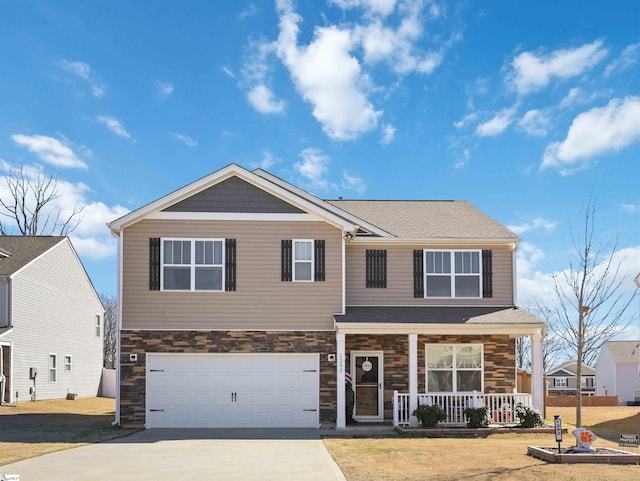 view of front of property featuring a porch, an attached garage, stone siding, driveway, and a front lawn