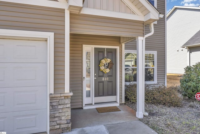 property entrance with board and batten siding and an attached garage