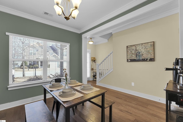 dining space with visible vents, ornamental molding, wood finished floors, stairs, and a chandelier