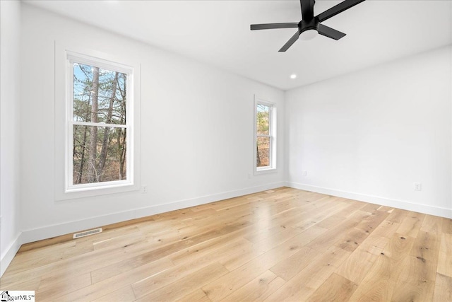 unfurnished room featuring baseboards, visible vents, ceiling fan, and light wood finished floors