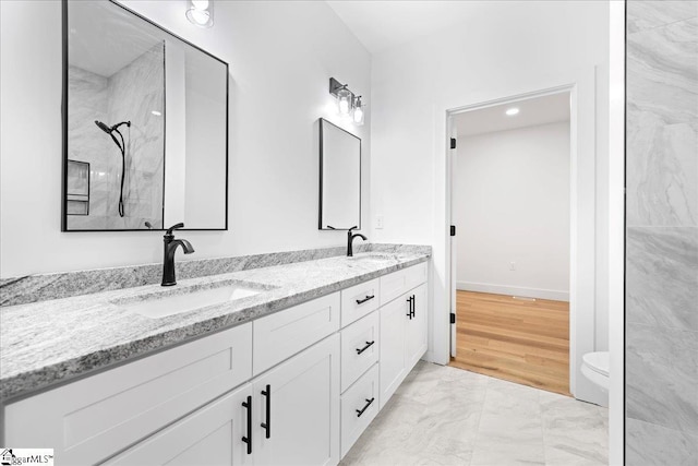 full bath featuring toilet, a sink, marble finish floor, a shower, and double vanity