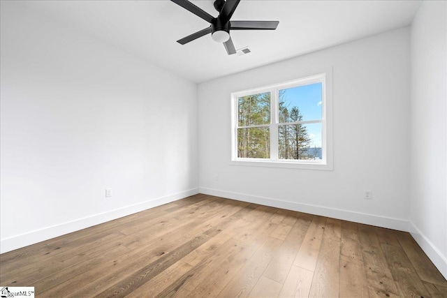 spare room featuring a ceiling fan, baseboards, visible vents, and wood finished floors