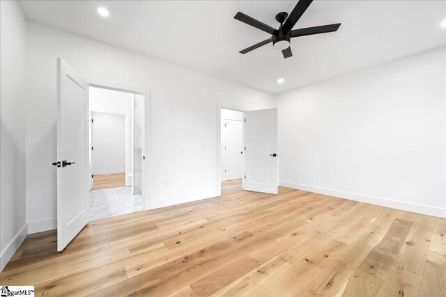 unfurnished bedroom with light wood finished floors, baseboards, ensuite bathroom, and recessed lighting