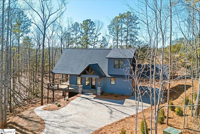 chalet / cabin with driveway and a shingled roof