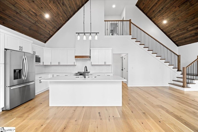 kitchen featuring white cabinets, light countertops, and stainless steel refrigerator with ice dispenser