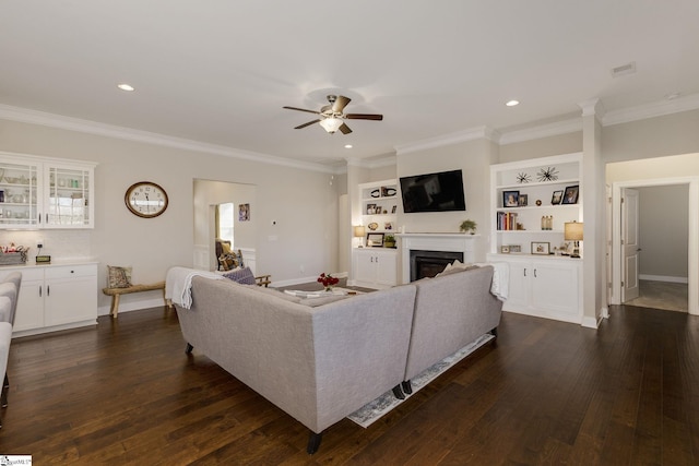 living area with dark wood-type flooring, crown molding, a fireplace, and baseboards