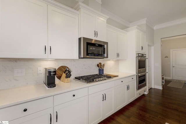 kitchen featuring crown molding, stainless steel appliances, light countertops, decorative backsplash, and white cabinetry