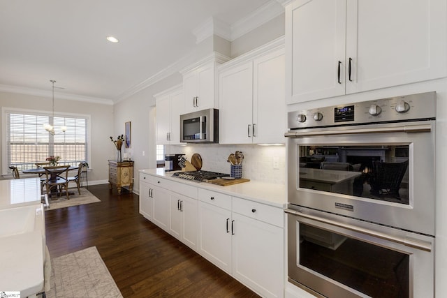 kitchen featuring tasteful backsplash, dark wood-style flooring, stainless steel appliances, crown molding, and light countertops