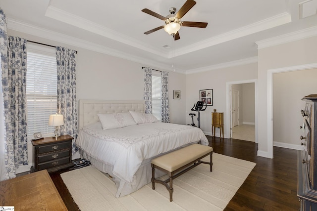 bedroom featuring baseboards, a tray ceiling, hardwood / wood-style floors, and ornamental molding