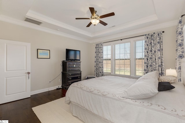 bedroom featuring baseboards, visible vents, dark wood-type flooring, and a tray ceiling