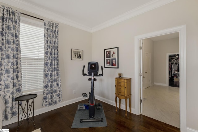 exercise area with baseboards, ornamental molding, and wood finished floors