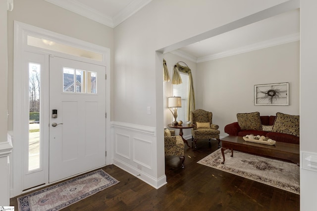 entryway with ornamental molding, dark wood-type flooring, and wainscoting