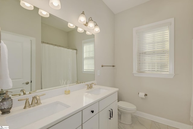 bathroom with marble finish floor, a sink, toilet, and baseboards