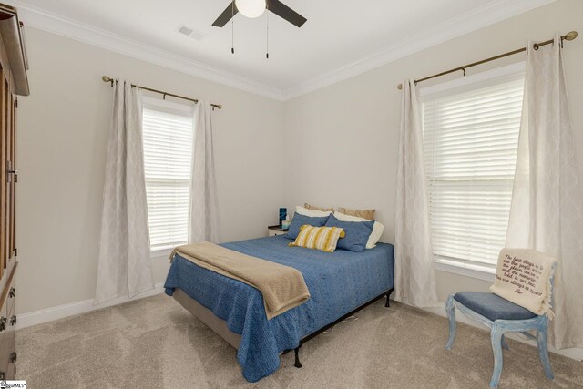 carpeted bedroom with ceiling fan, visible vents, crown molding, and multiple windows