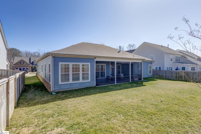 back of property featuring a yard, a fenced backyard, and a sunroom