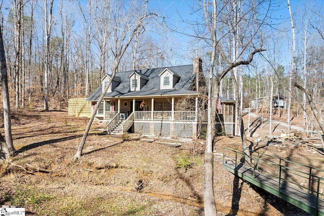 cape cod-style house with stairs and a porch