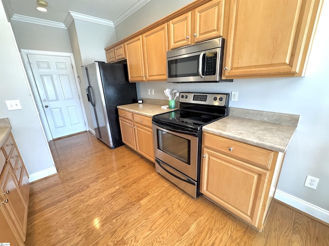 kitchen featuring light countertops, appliances with stainless steel finishes, light wood-style floors, and crown molding