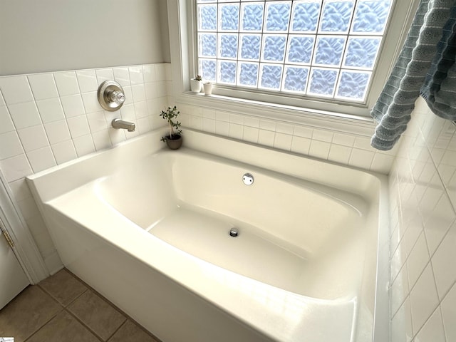 bathroom with a garden tub and tile patterned floors