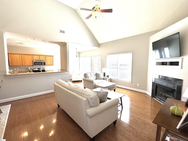 living room with ceiling fan, a fireplace, visible vents, and dark wood-type flooring