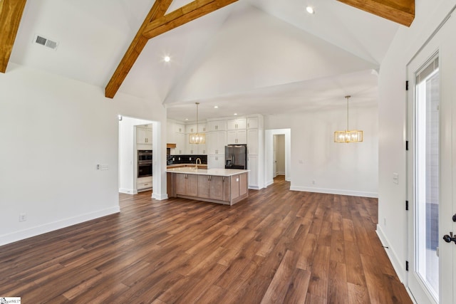 kitchen with white cabinetry, light countertops, a large island, appliances with stainless steel finishes, and decorative light fixtures