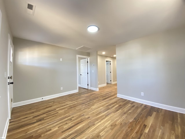 unfurnished room featuring visible vents, baseboards, and wood finished floors