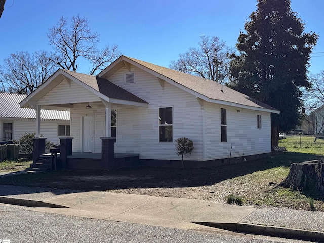 view of front of house with crawl space, a porch, and roof with shingles