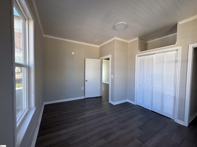 unfurnished bedroom with baseboards, a closet, dark wood finished floors, and crown molding