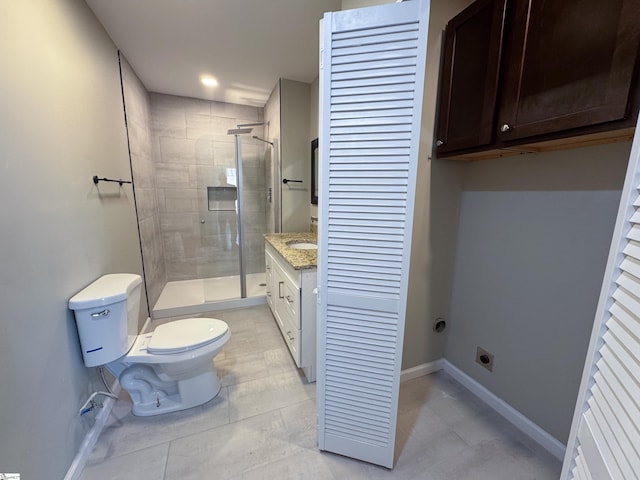 bathroom with a closet, toilet, a shower stall, vanity, and baseboards