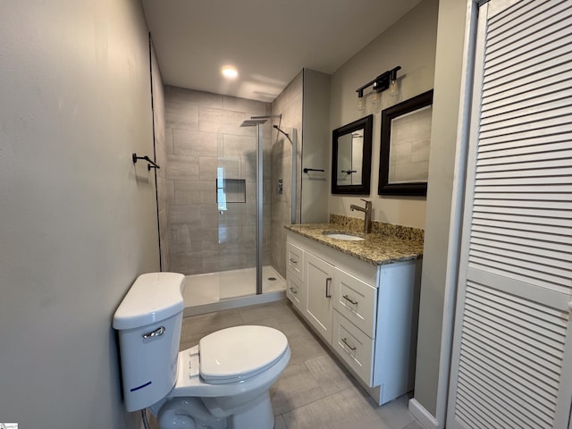 full bath featuring a closet, vanity, toilet, and a stall shower