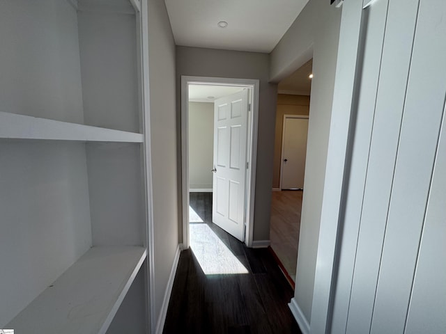 corridor with dark wood-type flooring and baseboards