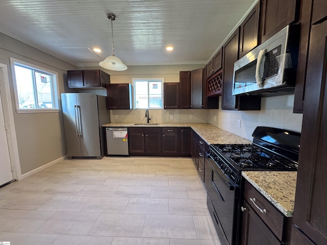 kitchen with light stone counters, decorative light fixtures, a sink, stainless steel appliances, and backsplash