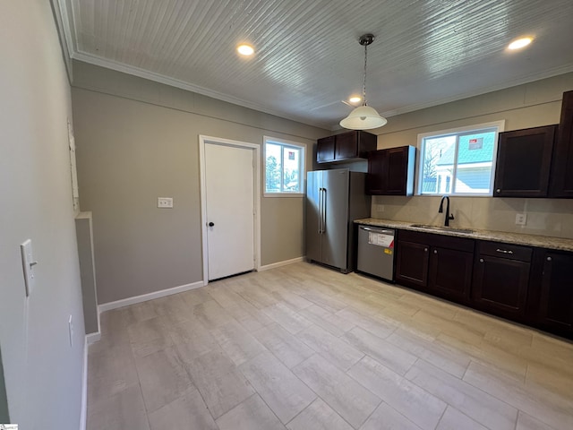 kitchen with dark brown cabinetry, stainless steel appliances, a sink, baseboards, and light stone countertops