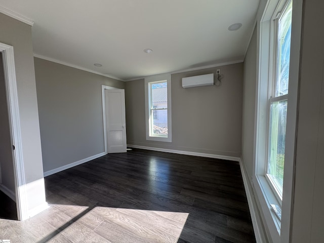 unfurnished room with dark wood-style flooring, a wall unit AC, crown molding, and baseboards