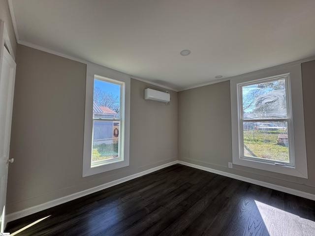 spare room featuring plenty of natural light, dark wood-type flooring, a wall mounted air conditioner, and baseboards