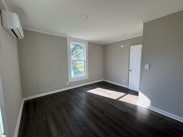 empty room featuring ornamental molding, dark wood-type flooring, a wall mounted air conditioner, and baseboards