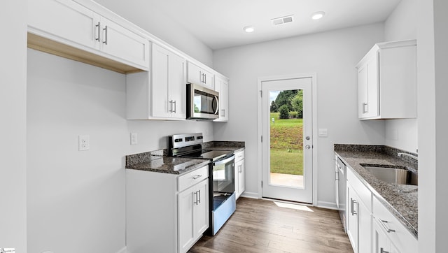 104 Sunriff Ct, Greer, SC 29651 - kitchen with appliances with stainless steel finishes, wood finished floors, dark stone countertops, white cabinets, and recessed lighting