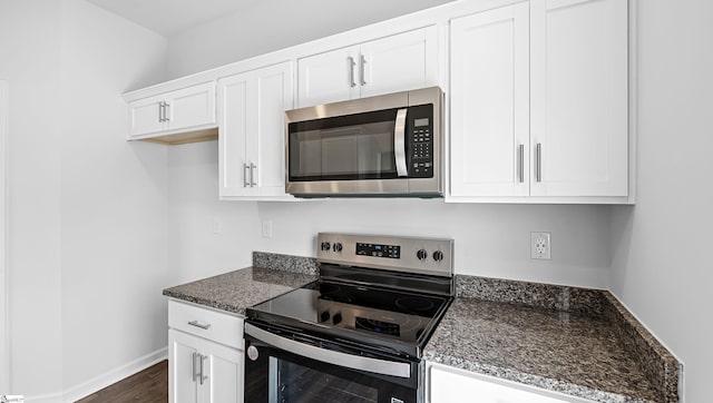 104 Sunriff Ct, Greer, SC 29651 - kitchen with appliances with stainless steel finishes, white cabinetry, dark wood-style floors, and dark stone counters