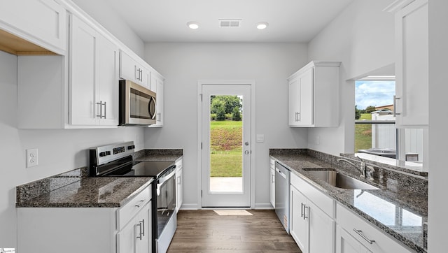 104 Sunriff Ct, Greer, SC 29651 - kitchen featuring stainless steel appliances, dark wood-style floors, white cabinets, dark stone counters, and recessed lighting