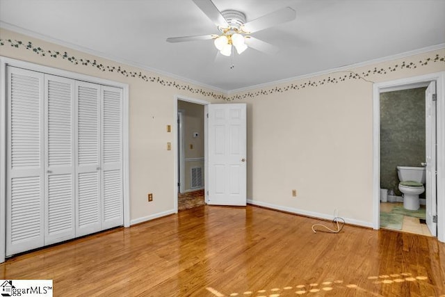 unfurnished bedroom featuring baseboards, a closet, ornamental molding, and wood finished floors